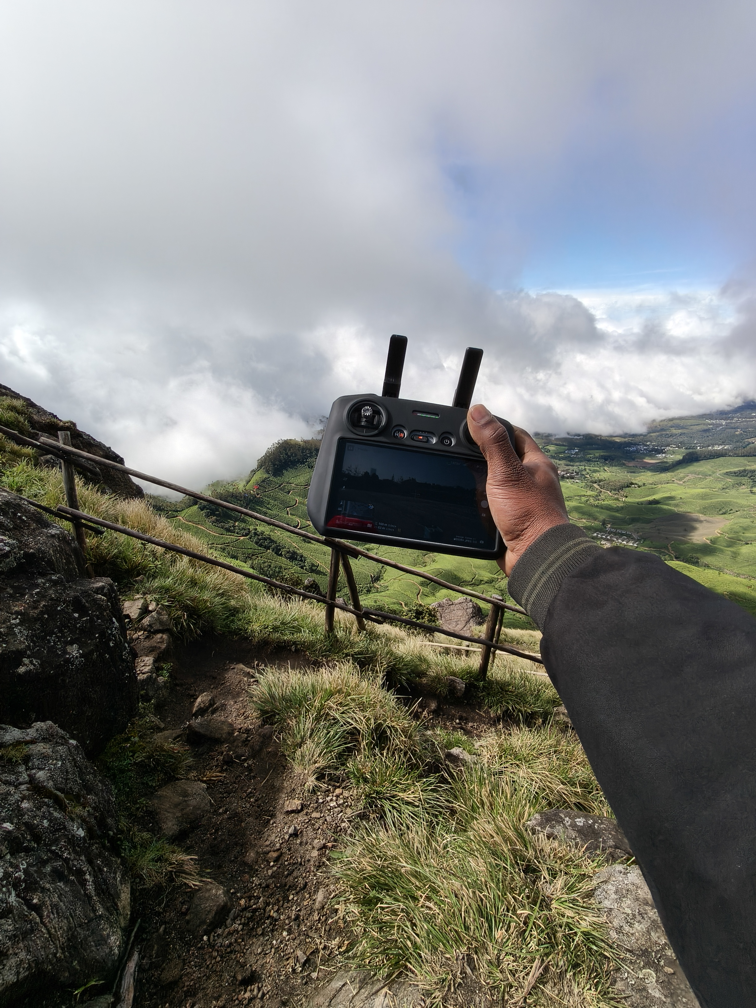 Kolukkumalai mountain peak view with floating clouds and green tea plantations